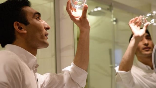  Man looks at lightbulb